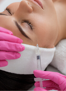 Woman getting injectables inserted next to her eye