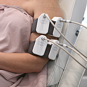 Woman's arm as she sits in chair during body countour treatment